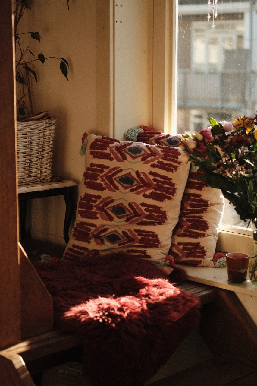 Flora in a warm, calm space with books and soft natural light.